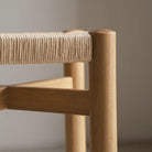 POOTOO's Solid Wood & Woven Straw Vintage Low Stool Side Detail Image Showcasing the intricate craftsmanship and design features, highlighting the sturdy structure and rustic appeal of this low stool.