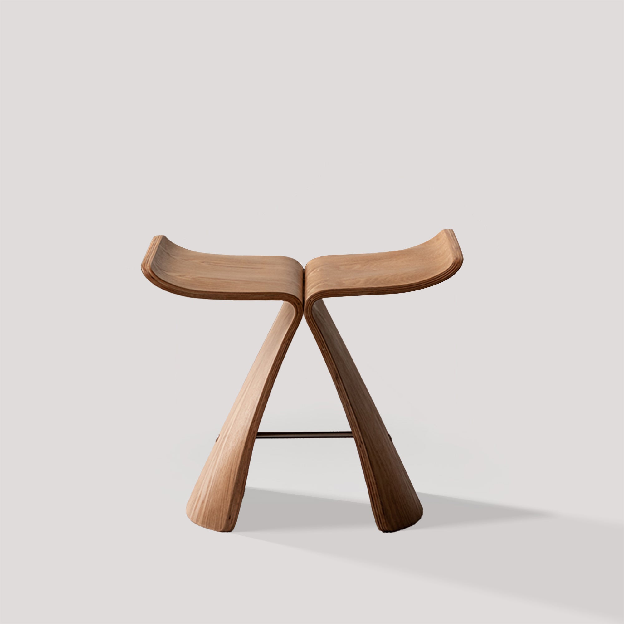 The Pootoo butterfly stool is displayed against a white background, showcasing its unique streamlined design and exquisite wood grain. The sides of the stool spread out like butterfly wings, giving it an elegant overall shape that fits various interior environments.